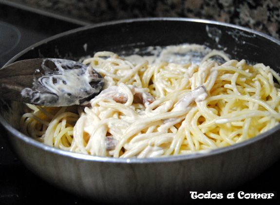 Espaguetis a la carbonara - Mezclando el bacon con la nata y los espaguetis