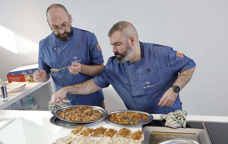 Los cocineros preparando su Paquito